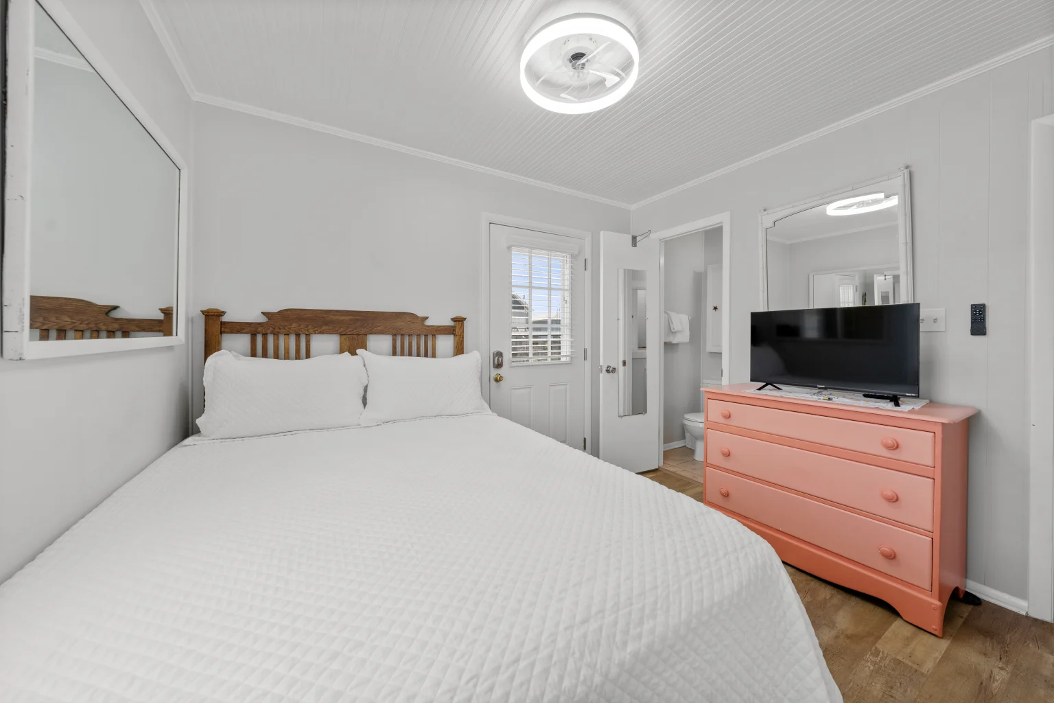 Queen bedroom with coral dresser and TV, Beach Cottage