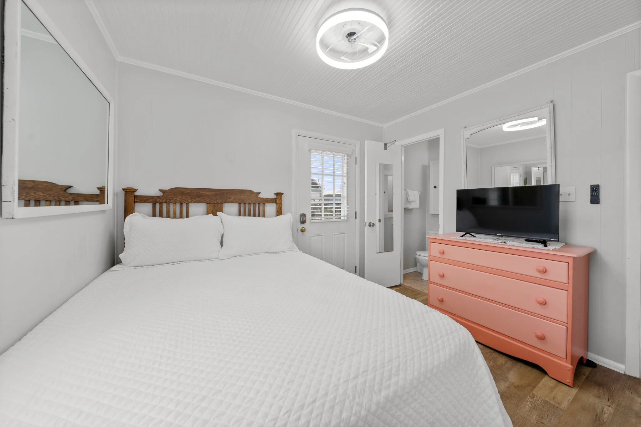 Queen bedroom with coral dresser and TV, Beach Cottage