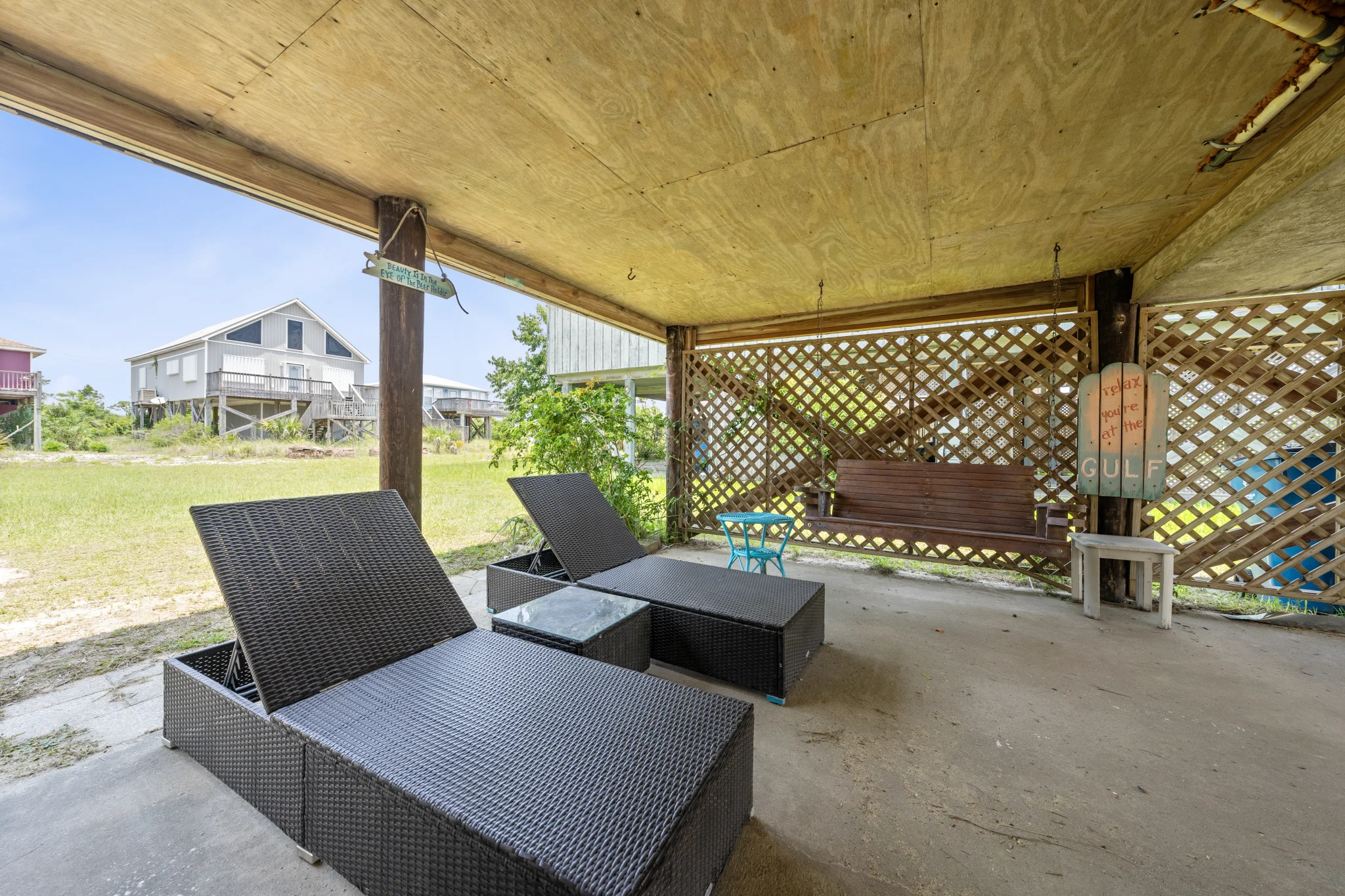 Covered patio with loungers under the cottage, Beach Cottage