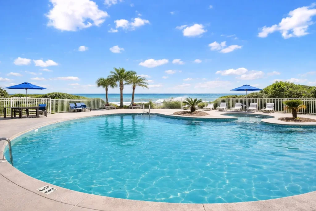 Resort pool with palm trees beside the beach at Emerald Dreams