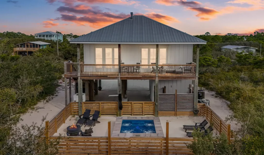 Gulf Pearl at sunset, with a hot tub and fire pit beside the house