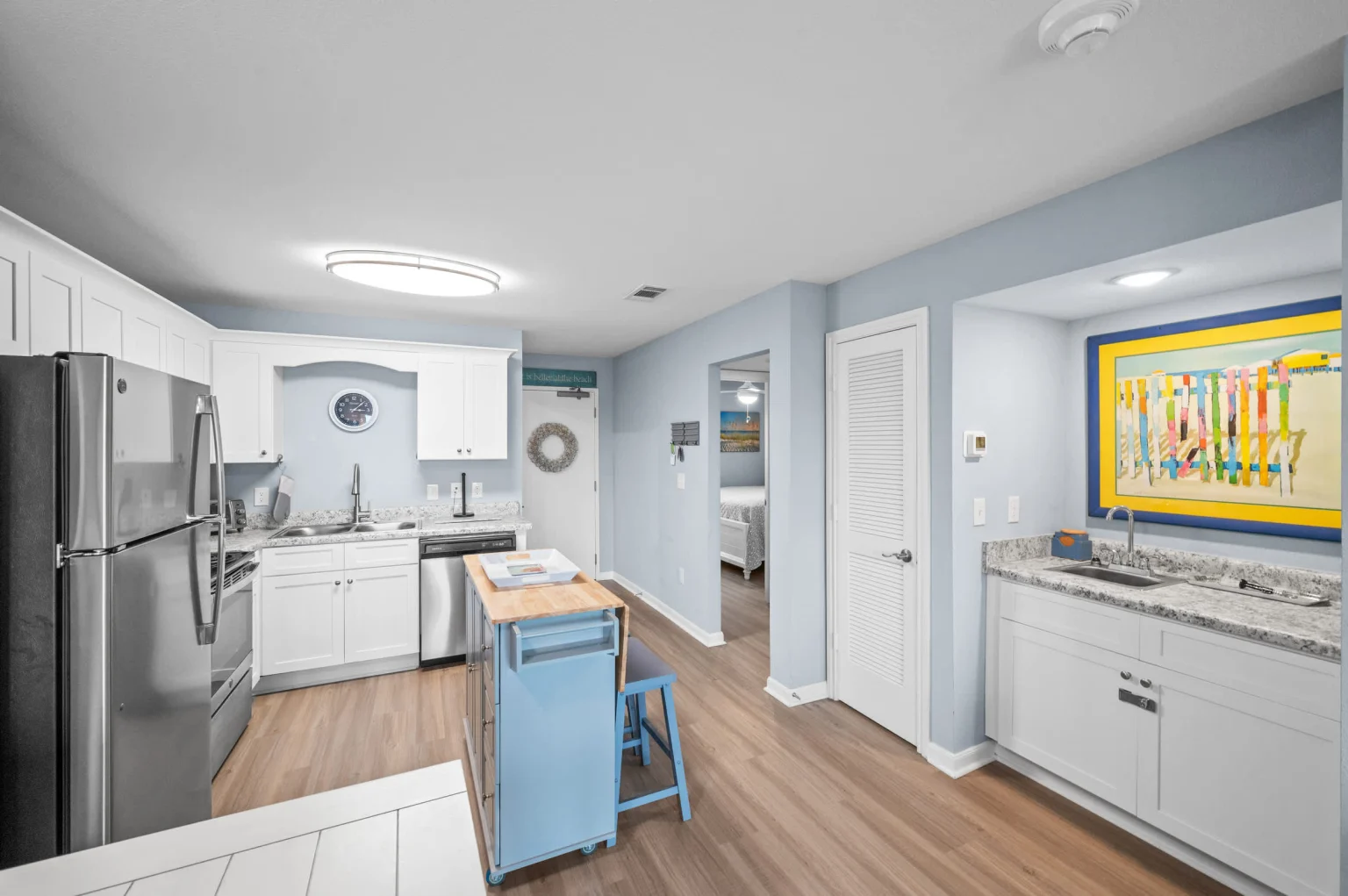 Kitchen with stainless appliances and a blue island, Emerald Dreams