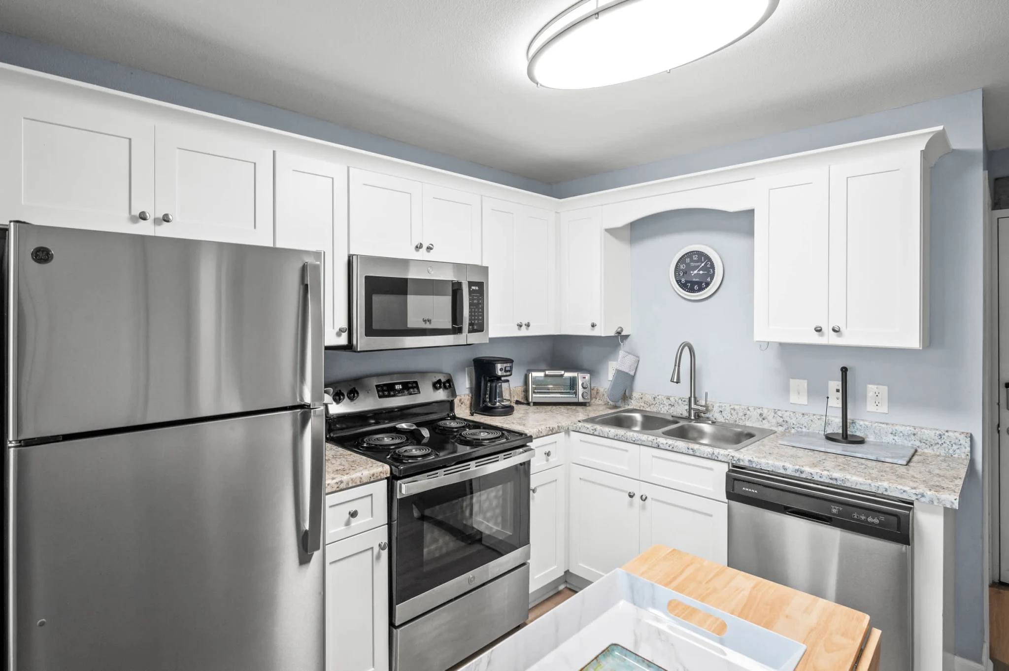 Kitchen with white cabinets and a stainless range, Emerald Dreams