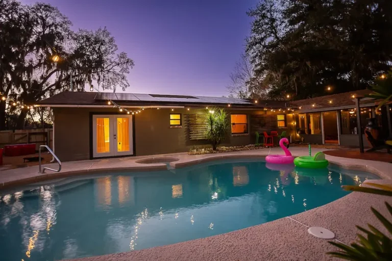 Saltwater pool lit at dusk at a home in Gainesville
