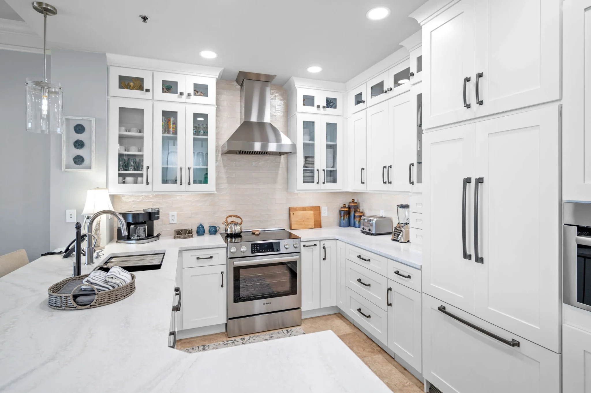 Kitchen with white cabinets and stainless range hood, High Tide Penthouse