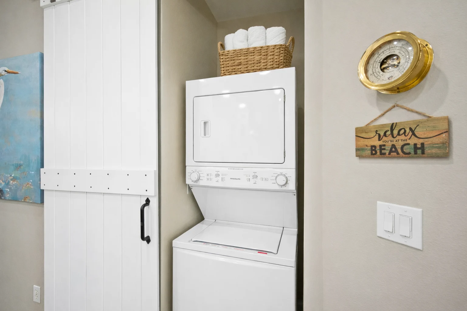 Stacked washer and dryer behind a barn door, High Tide Penthouse