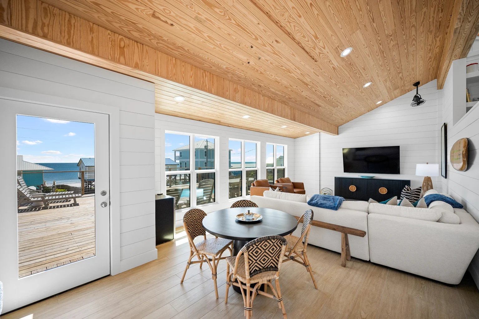 Open living room with wood ceiling and round dining table, Love Shack