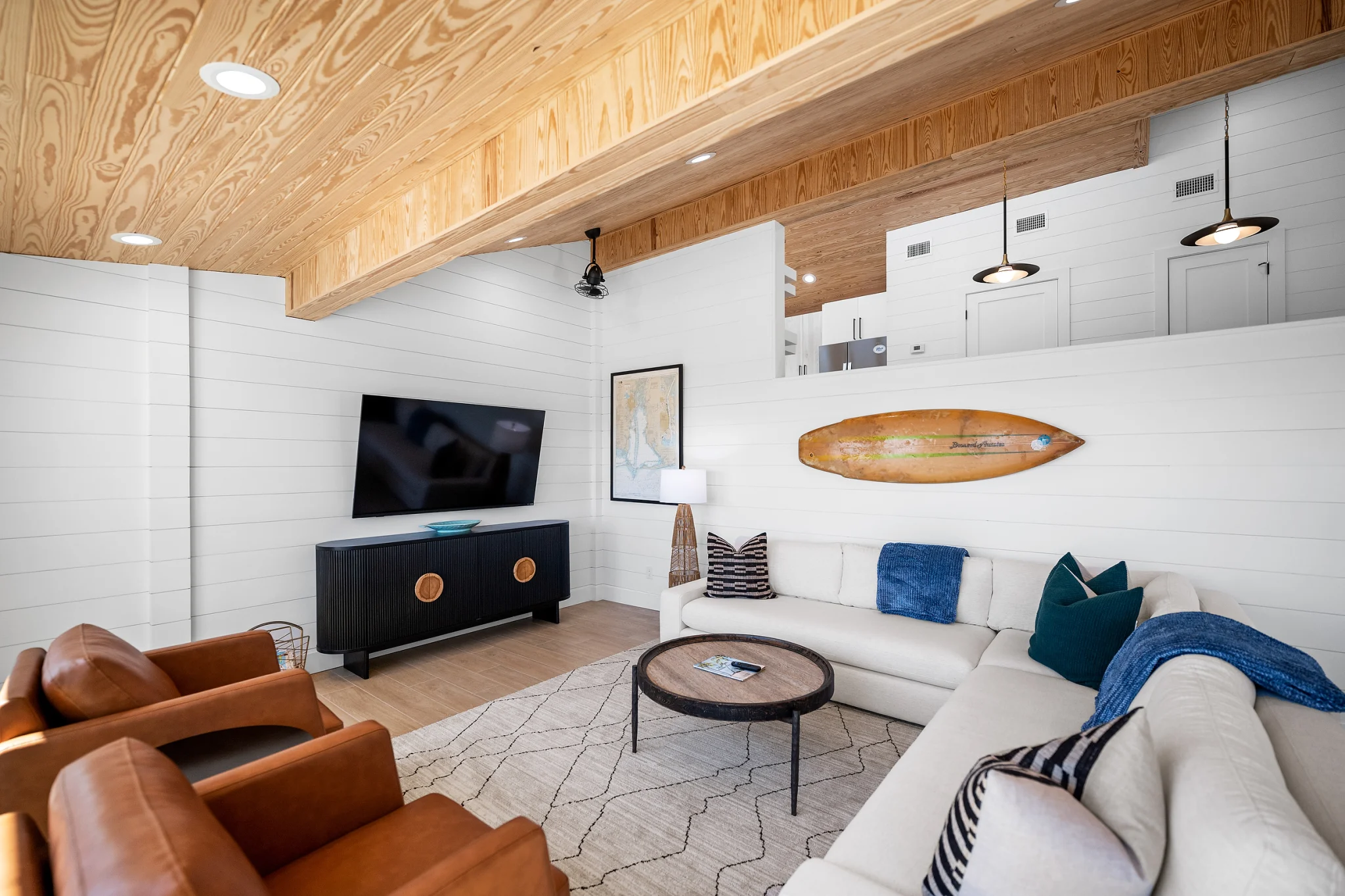 Living room with leather chairs and surfboard art, Love Shack