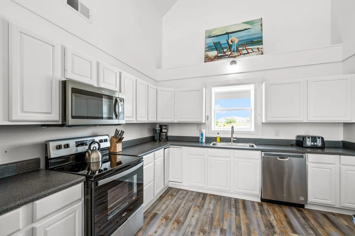 Kitchen with white cabinets and stainless appliances, Sands of Time