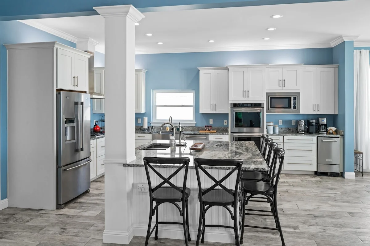 Kitchen and island seating seen past a column, Sea Bliss