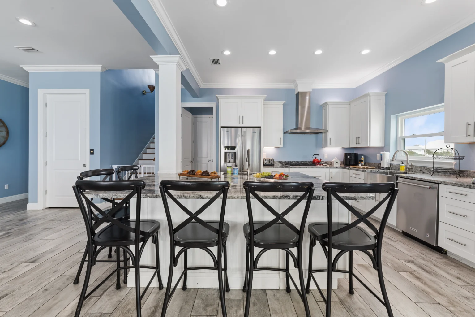 Bar stools at the island with the kitchen behind, Sea Bliss