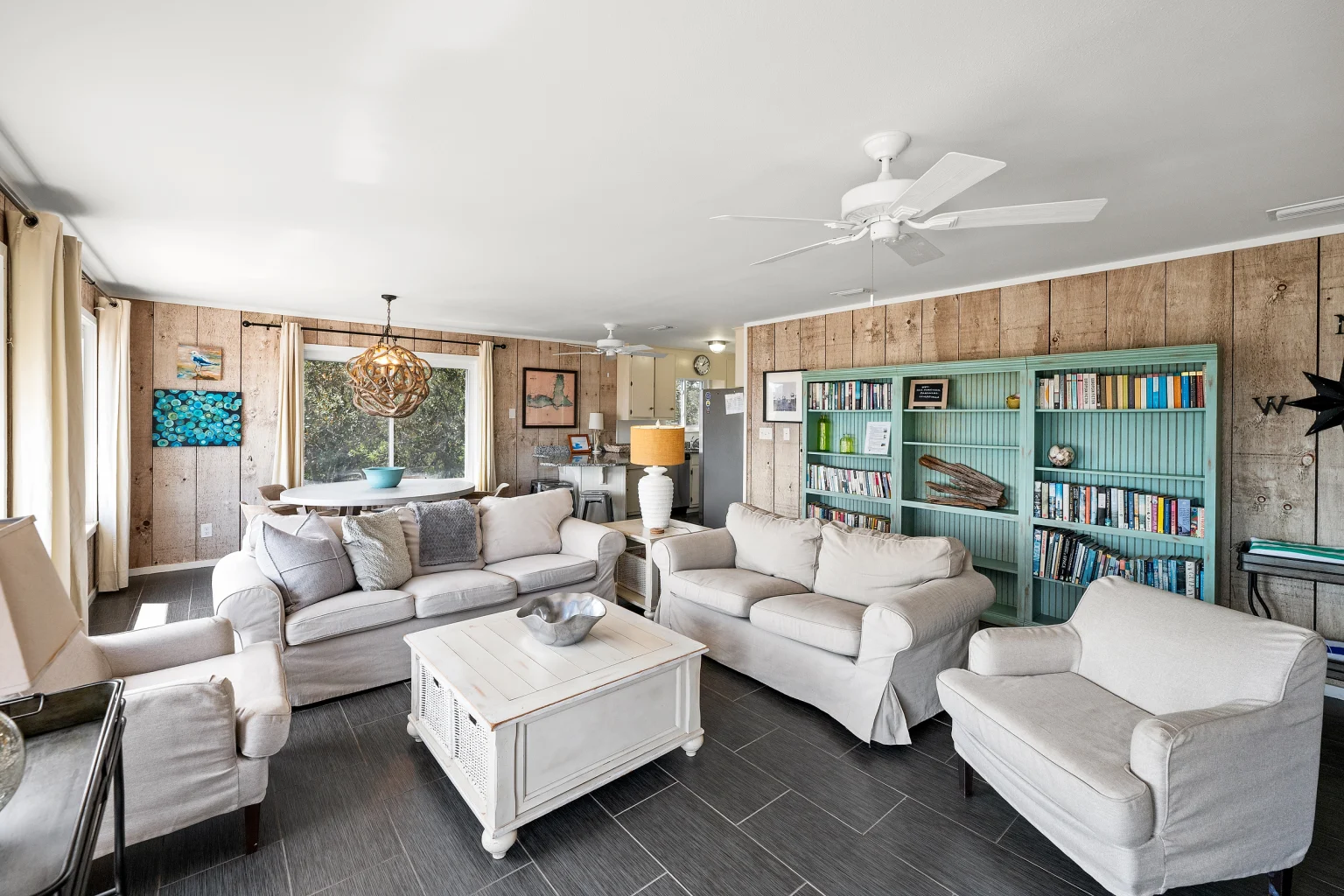 Living room with slipcovered sofas and built-in bookshelves, Sea Forever