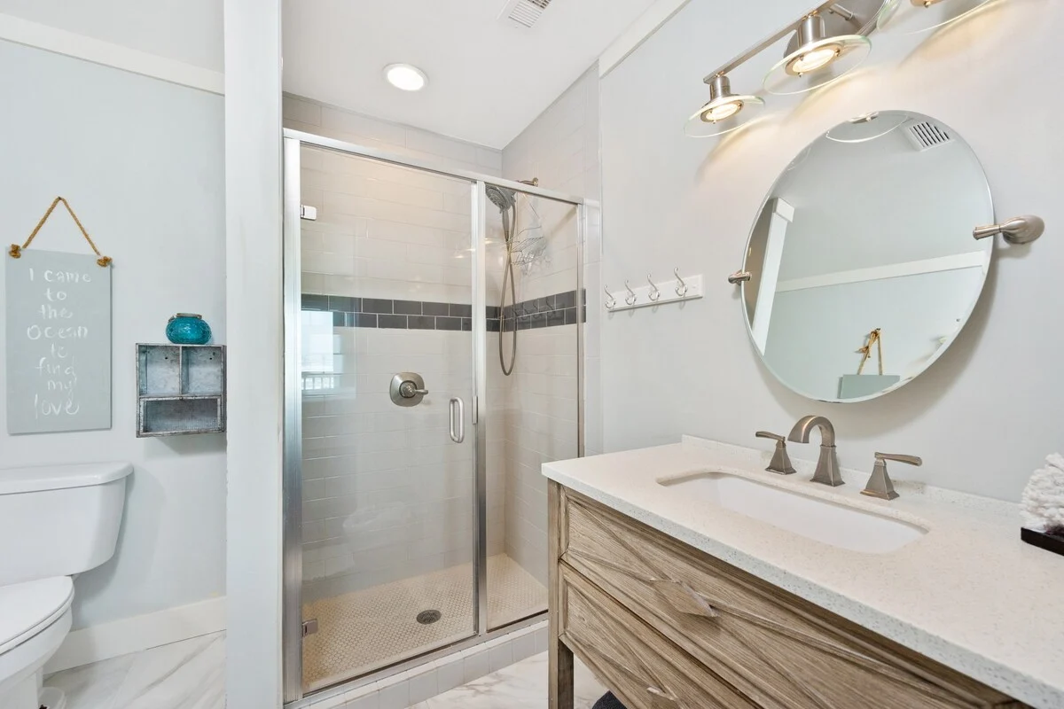 Bathroom with round mirror and glass shower, SouthWind West