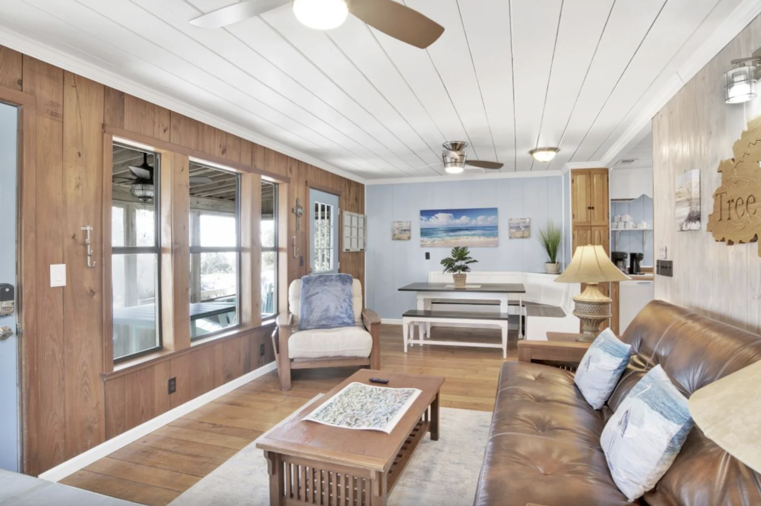 Living room with leather sofa and wood-paneled walls, Tree Tops