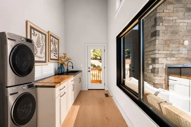 Laundry room with a stacked washer and dryer and utility sink, View Finder II